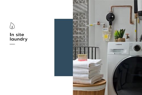 a laundry room with a washing machine and a stack of towels at Azul Cordoba By The Local Way in Mexico City