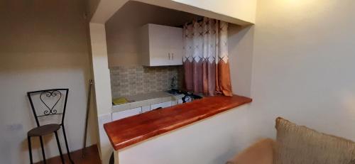 uma pequena cozinha com um lavatório e uma janela em Lena Cottage em Nanyuki