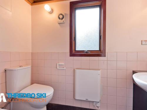 łazienka z toaletą, umywalką i oknem w obiekcie Sneznik w mieście Thredbo