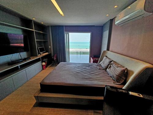 une chambre avec un lit et une vue sur l'océan dans l'établissement Casa Áurea! A 100 metros da areia de Ponta Negra, com vista deslumbrante do mar, à Natal