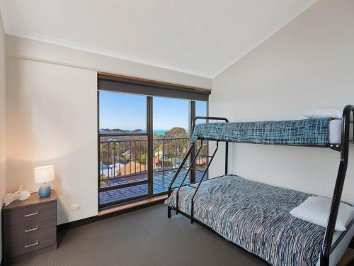 納魯馬的住宿－Sheridan Court on Wagonga，一间带双层床的卧室和一个阳台