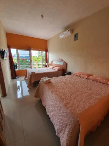 a hotel room with two beds and a window at APARTHOTEL VISTA LAGO in Flores