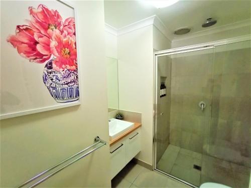 a bathroom with a sink and a vase of flowers on the wall at My Abode in Albury in Albury