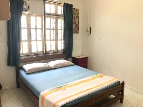 a bed in a room with a window and a bed sidx sidx sidx at AbgZul Homestay in Kota Bharu
