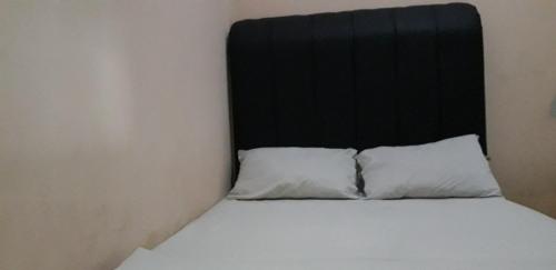Un pat sau paturi într-o cameră la OYO 90706 Kost Alam Jaya Syariah