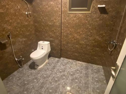 a bathroom with a toilet and a shower stall at شقق القارات السبع الاحساء in Al Hofuf