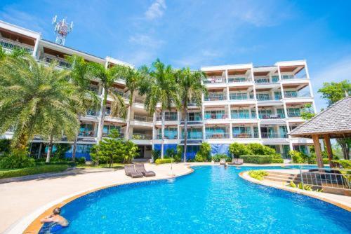 a swimming pool in front of a large building at Spacious apartment with Ocean view in Panwa in Phuket