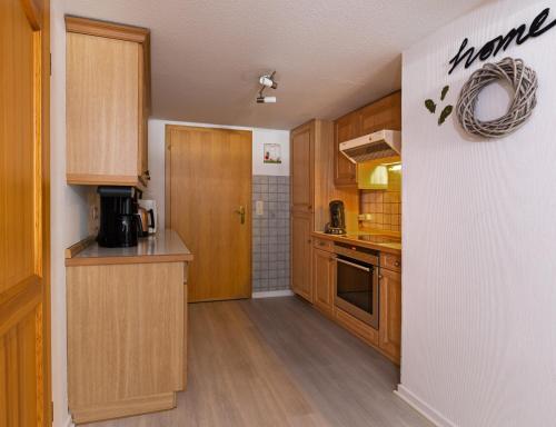- une cuisine avec des placards en bois et un comptoir dans l'établissement Landferienwohnung Simon, à Schmallenberg