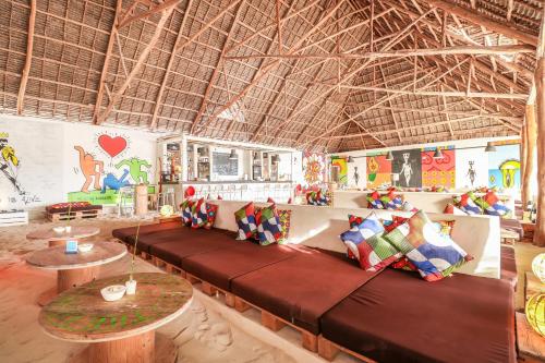 a room with a long couch with pillows on it at The Loop Beach Resort- Adults Only in Jambiani