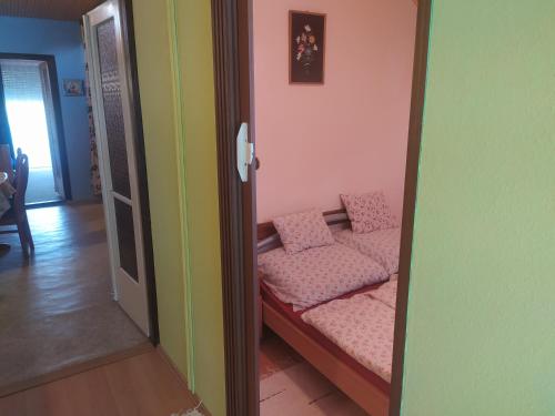 a room with a couch with pink pillows on it at Etus Vendégház in Balatonfenyves