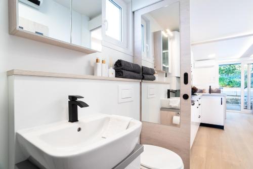 a white bathroom with a sink and a toilet at The Sea Lodges Portoroz - Bootshaus Floating Sea House in Portorož