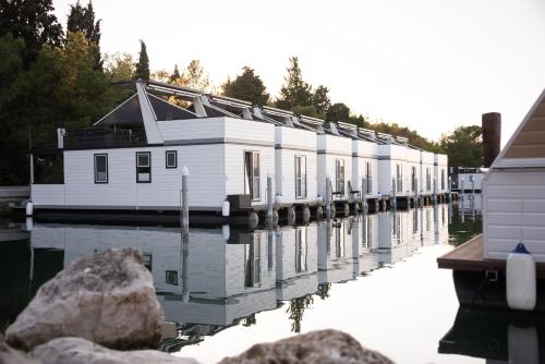 a row of houses on a dock on the water at The Sea Lodges Portoroz - Hausboot Floating Sea House in Portorož
