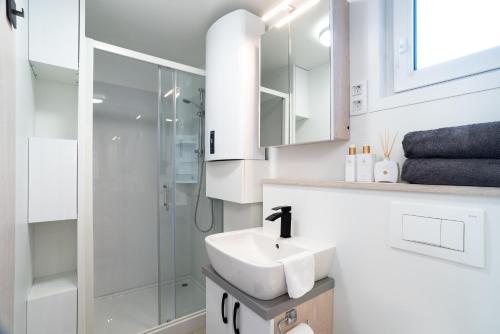 a white bathroom with a sink and a shower at The Sea Lodges Portoroz - Hausboot Floating Sea House in Portorož