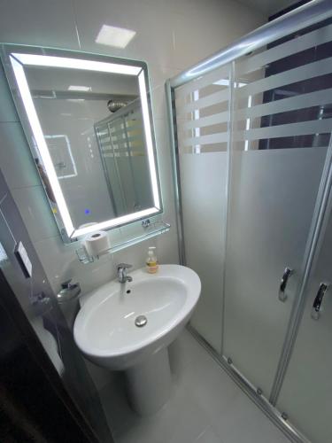 W łazience znajduje się umywalka oraz prysznic z lustrem. w obiekcie Welcome Baku Apartment w mieście Baku
