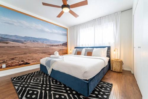 a bedroom with a large bed with a ceiling fan at Splash and Relax by HomeSlice Stays in Scottsdale