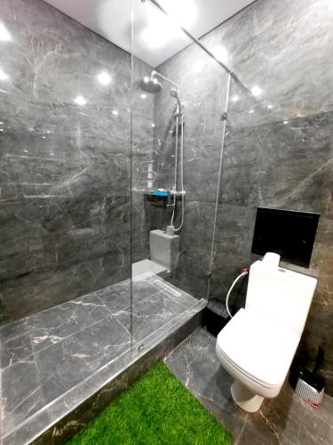 a bathroom with a toilet and a glass shower at Исы Байзакова 133 in Pavlodar