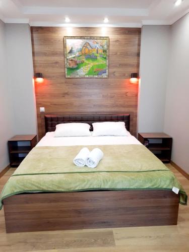 a bedroom with a large bed with two towels at Исы Байзакова 133 in Pavlodar