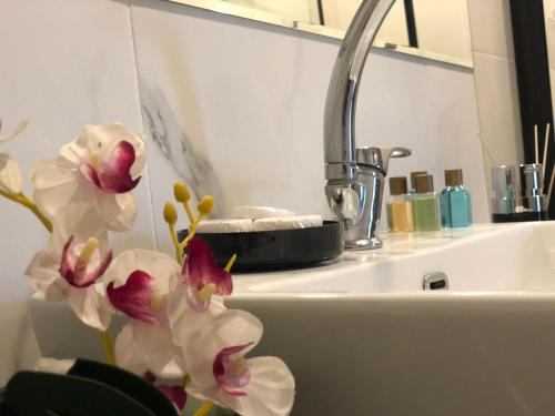 un baño con lavabo y flores en una encimera en Nova Suite Hotel, en Trabzon