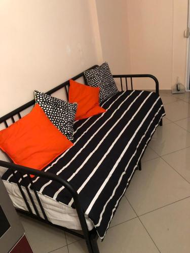 a bed with orange and black pillows on it at Luxury Apartment Krisi Sarandë in Sarandë