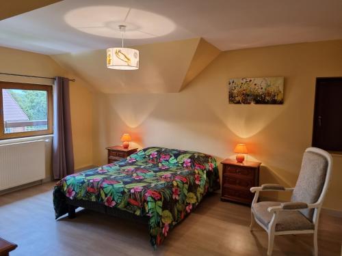 a bedroom with a bed and two chairs and a window at Les gites Haras Del Paradiso in Boitron