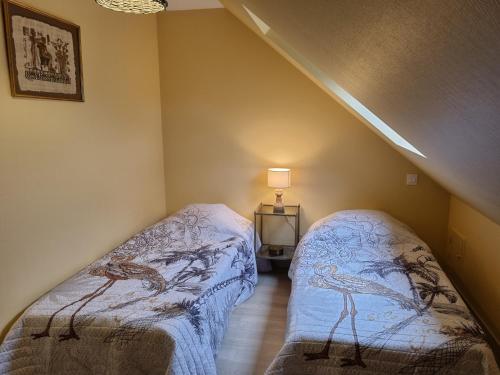 a bedroom with two beds in a attic at Les gites Haras Del Paradiso in Boitron