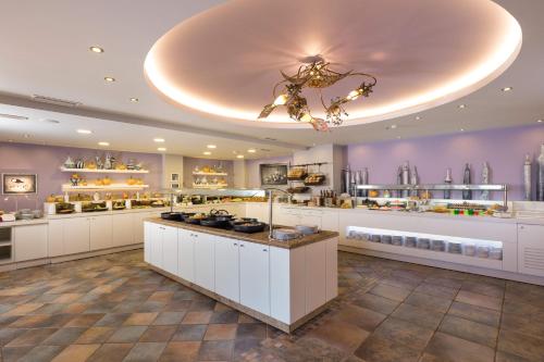 a large kitchen with white cabinets and a chandelier at Alianthos Garden in Plakias