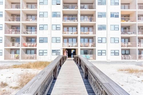 a boardwalk leading to the beach in front of a building at Island Shores Condos in Gulf Shores