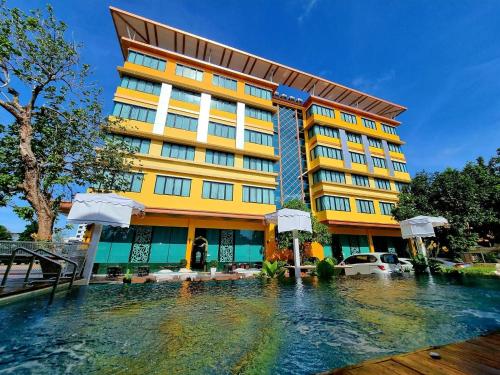 a hotel with a pool of water in front of it at Gallery Design - SHA Extra Plus in Si Sa Ket