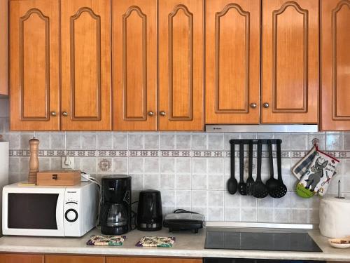 a kitchen with wooden cabinets and a microwave at Traditional House of Diafani in Karpathos Town