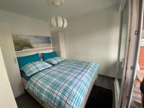 ein Schlafzimmer mit einem Bett mit Kissen und einem Fenster in der Unterkunft Ferienwohnungen Felix und Jan in Horumersiel