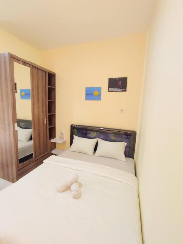 a bedroom with a bed with a white stuffed animal on it at La Tana Hotel in Bagongsabrangan