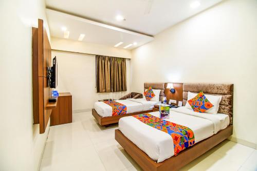 a hotel room with two beds and a television at FabHotel Prime President- Bhopal Railway Station in Bhopal