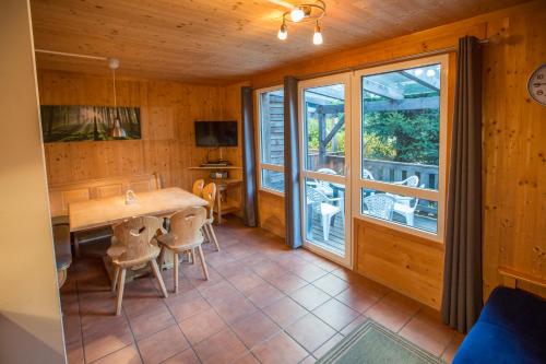 a dining room with a table and chairs and a balcony at Feriendorf Tauerngast in Hohentauern