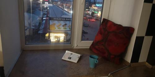a room with a book and a cup and a window at Dwell Apartments in Kremenchuk