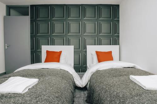 two beds in a room with green wall at HOMELY 3BD TOWNHOUSE w 2WCs 15MINS TO BHAM &WOLV in Tipton