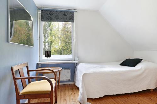 a bedroom with a bed and a chair and a window at Charming 3BR country house near Piteå & Skellefteå in Piteå