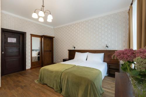 a bedroom with a bed with a green blanket at Verevi Motel in Elva