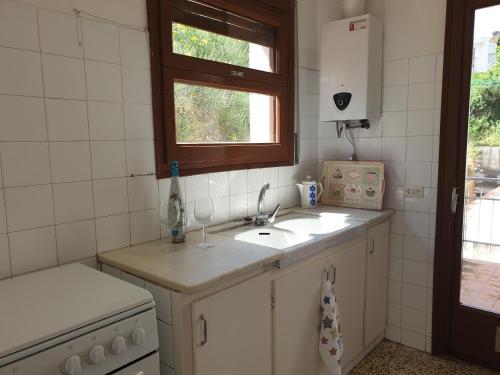 a kitchen with a sink and a window at Xaloc, apartament amb vistes a mar M4 in Port de la Selva
