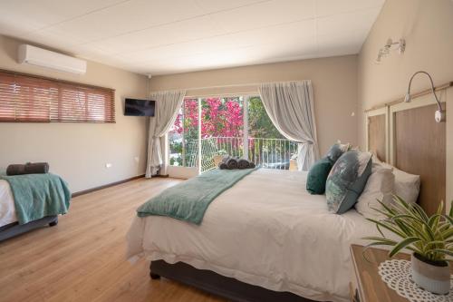a bedroom with a large bed and a large window at Opstal Gastehuis in Potchefstroom
