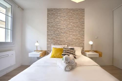 um quarto com uma grande cama branca e 2 candeeiros em La Balade Nîmoise Center Car Park AC em Nîmes