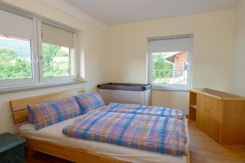 een slaapkamer met een bed en 2 ramen bij Ferienwohnung Hohenbogen in Neukirchen beim Heiligen Blut