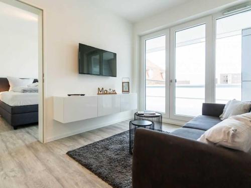 a living room with a couch and a tv at Hafenspitze App 10 in Wismar