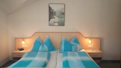 a bedroom with two blue pillows on a bed at Haus zur Linde in Wagrain