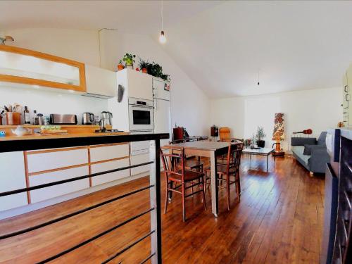 eine Küche und ein Wohnzimmer mit Tisch und Stühlen in der Unterkunft La maison de Thomas in Saint-Amant-de-Boixe