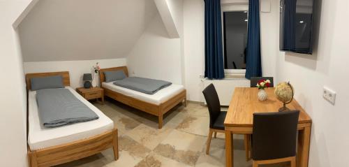 Habitación con 2 camas y mesa con escritorio. en Gasthaus zum Bären, en Donauwörth