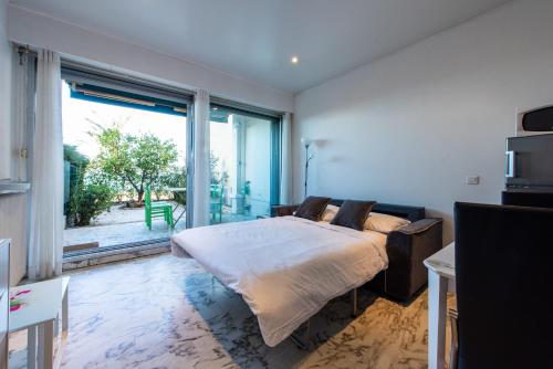 une chambre avec un lit et une grande fenêtre dans l'établissement Happyfew Eros, à Nice