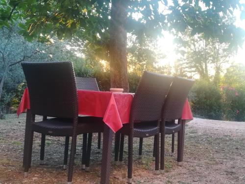 een tafel met twee stoelen en een rode tafelkleed bij La Casa Di Famiglia in Assisi