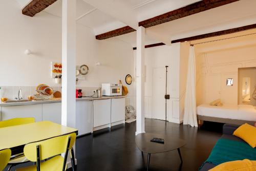 a kitchen and living room with a table and a bed at Mini Loft au coeur du Panier - Marseille in Marseille