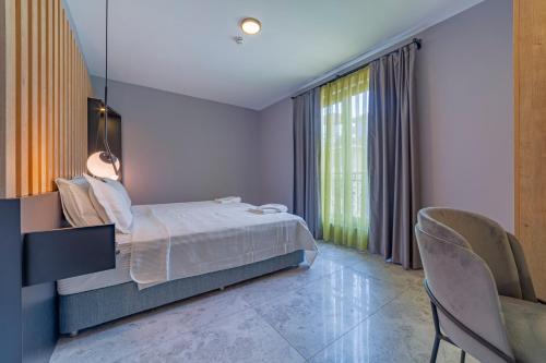 a bedroom with a bed and a window and chairs at Twin Apart Hotel in Alanya