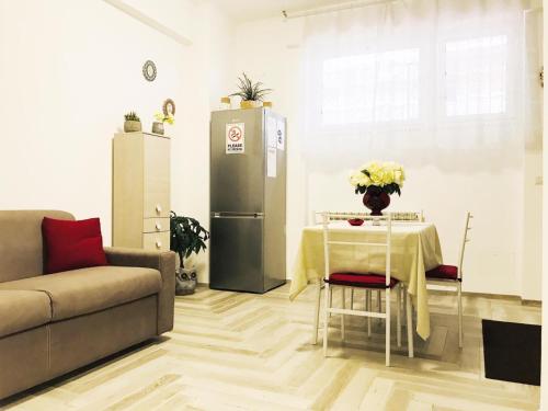 ein Wohnzimmer mit einem Tisch und einem Kühlschrank in der Unterkunft appartamento per mare o centro storico di Roma in Lido di Ostia